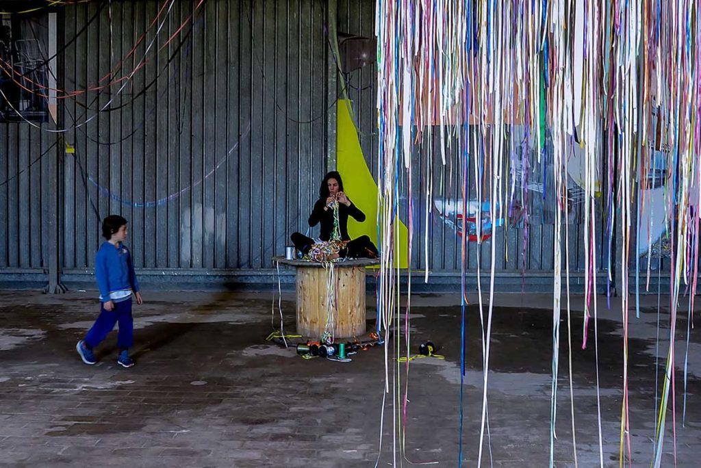 Só escapo pela porta da saída. Performance duracional realizada em 2016, dentro da instalação TENDA, da artista italiana Valéria Sanguini, no MAAM, Museo dell'Altro e dell'Altrove di Metropoliz), em Roma (IT). Ação movida: desenredar os fios de olhos fechados. Foto: Federico Riva