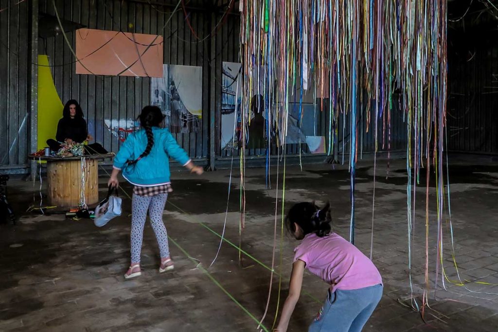 Só escapo pela porta da saída. Performance duracional realizada em 2016, dentro da instalação TENDA, da artista italiana Valéria Sanguini, no MAAM, Museo dell'Altro e dell'Altrove di Metropoliz), em Roma (IT). Ação movida: desenredar os fios de olhos fechados. Foto: Federico Riva