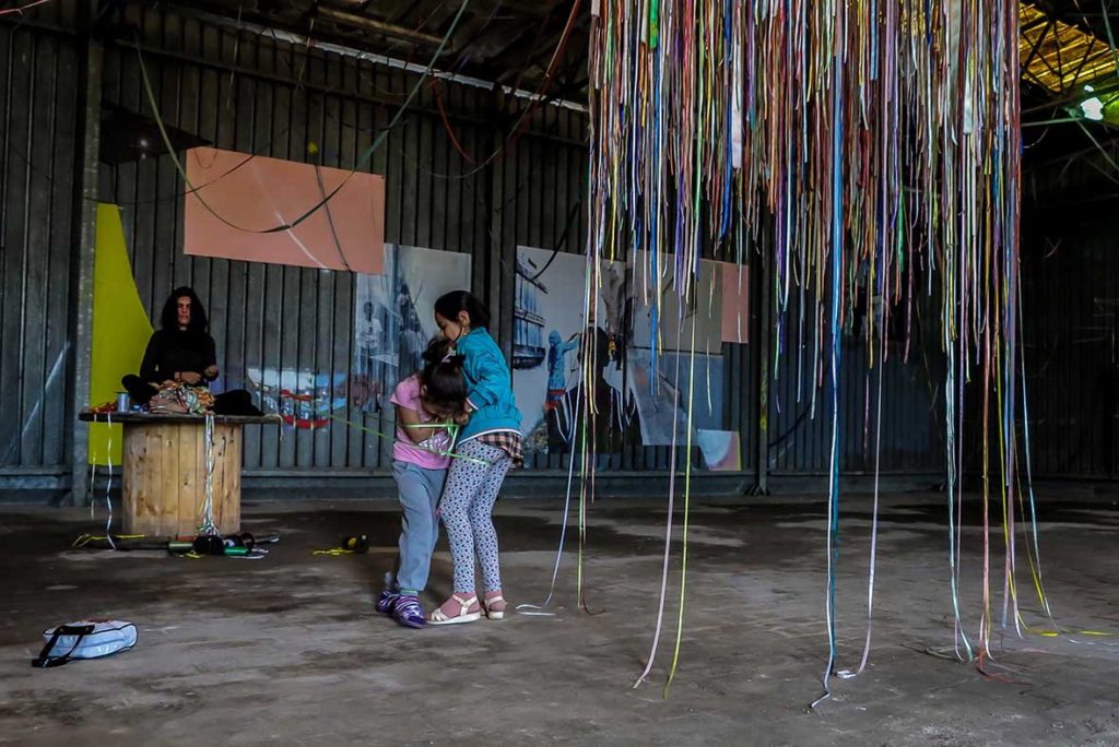 Só escapo pela porta da saída. Performance duracional realizada em 2016, dentro da instalação TENDA, da artista italiana Valéria Sanguini, no MAAM, Museo dell'Altro e dell'Altrove di Metropoliz), em Roma (IT). Ação movida: desenredar os fios de olhos fechados. Foto: Federico Riva