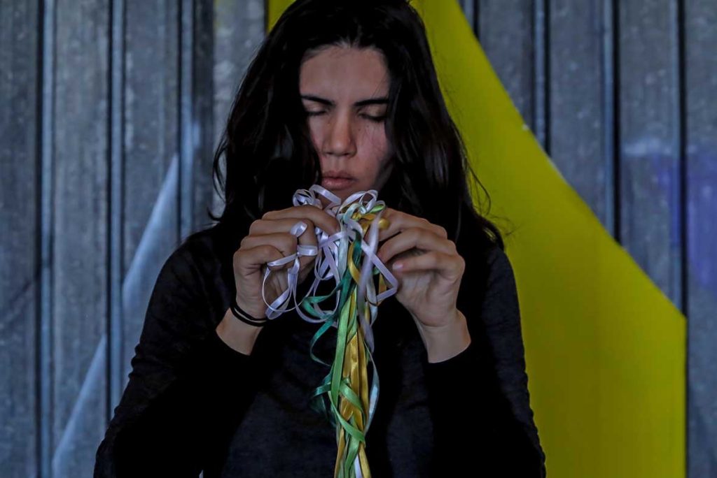 Só escapo pela porta da saída. Performance duracional realizada em 2016, dentro da instalação TENDA, da artista italiana Valéria Sanguini, no MAAM, Museo dell'Altro e dell'Altrove di Metropoliz), em Roma (IT). Ação movida: desenredar os fios de olhos fechados. Foto: Federico Riva