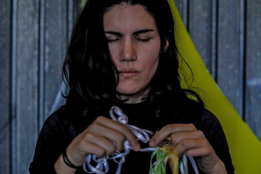 Só escapo pela porta da saída. Performance duracional realizada em 2016, dentro da instalação TENDA, da artista italiana Valéria Sanguini, no MAAM, Museo dell'Altro e dell'Altrove di Metropoliz), em Roma (IT). Ação movida: desenredar os fios de olhos fechados. Foto: Federico Riva